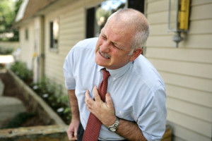businessman doubled over clutching his chest
